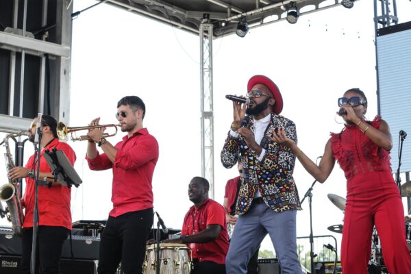 Color image of a group of musicians performing on an outdoor stage.