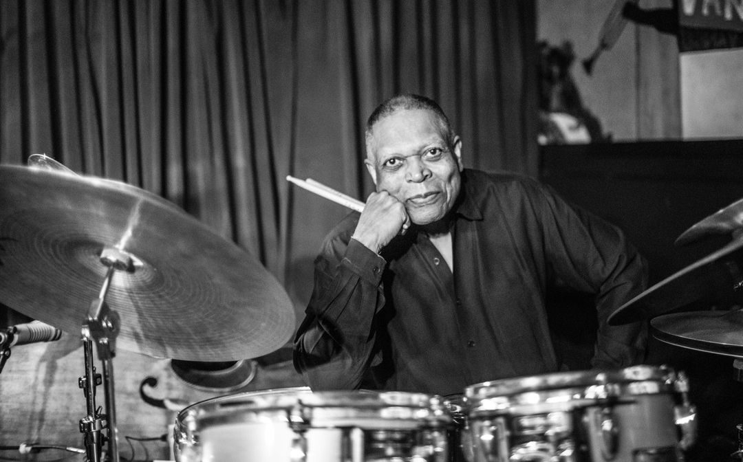 Black and white image of Billy Hart behind a drum kit.