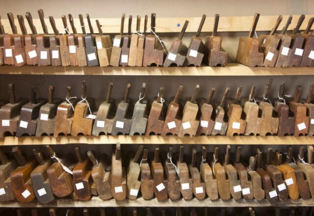 Three shelves of antique wooden forms are tagged and sorted by profile.