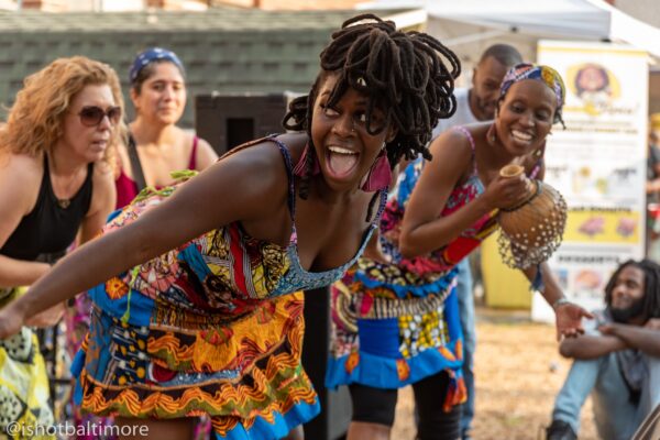 Color photo of women leading a African dance and drumming workshop.