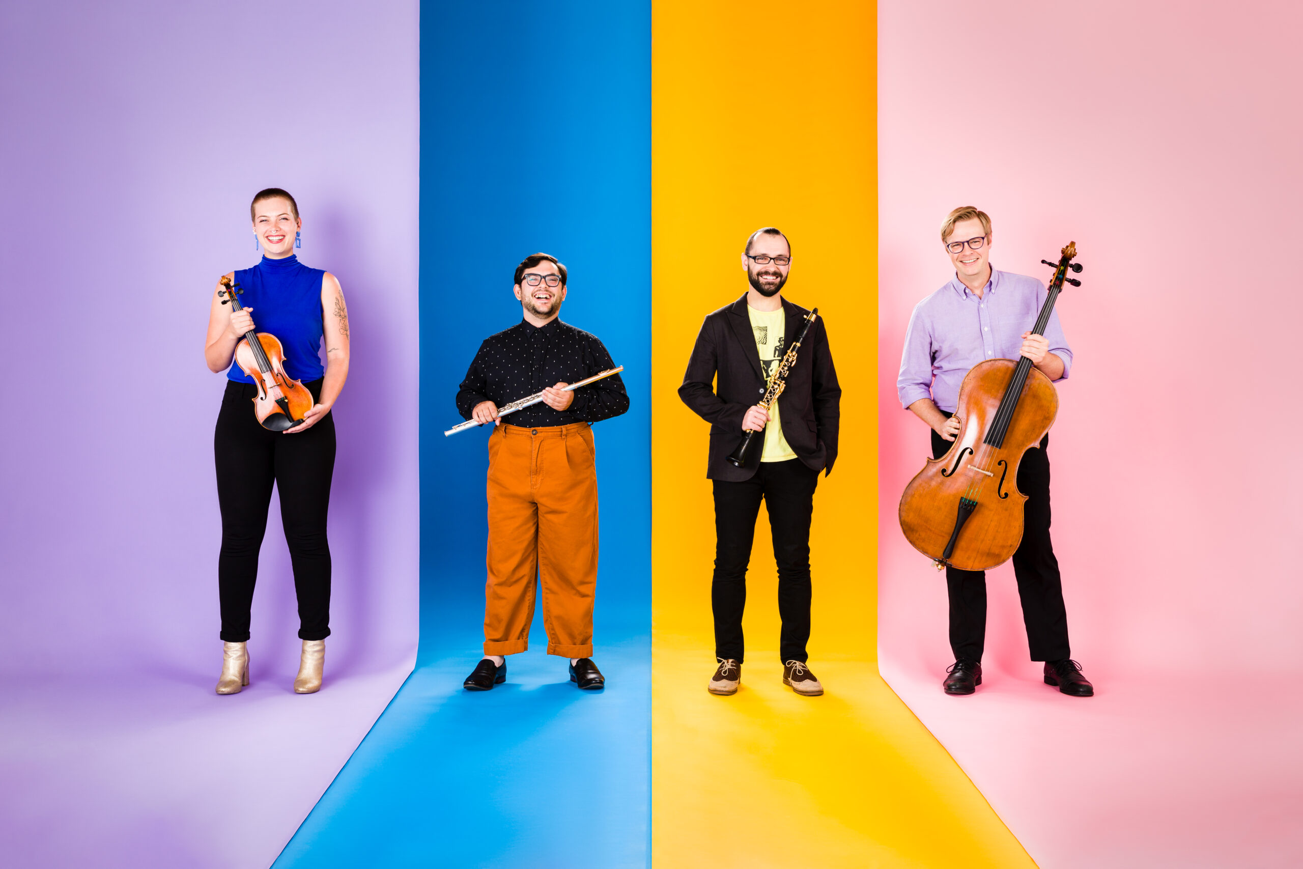 Color photos of four musicians holding their instruments while standing on a rainbow striped backdrop.