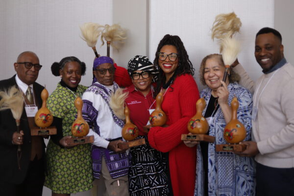 Seven storytellers pose with their awards and cowtail switches.