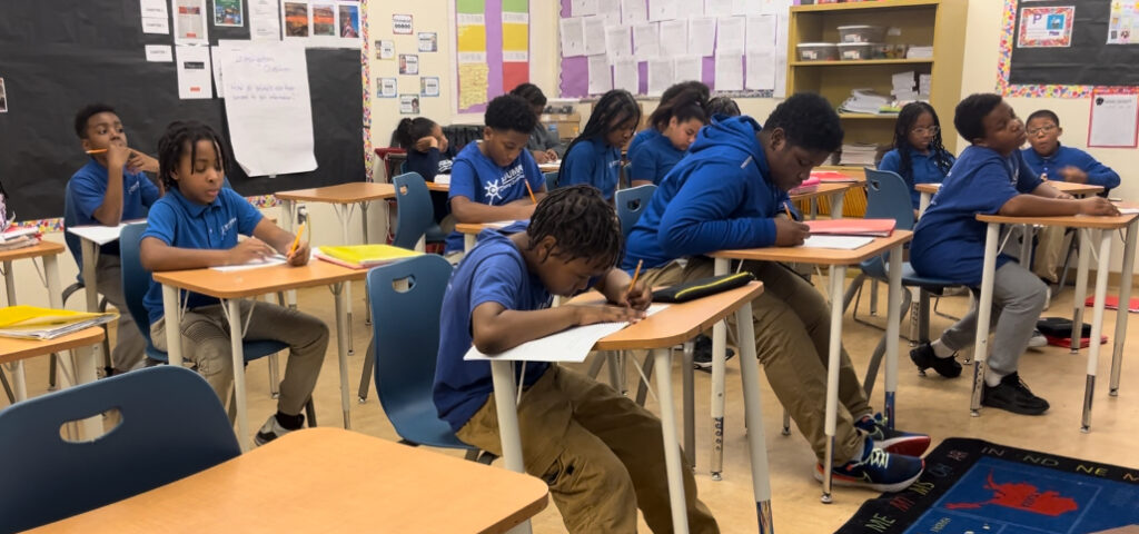 Students work at desks in a classroom.