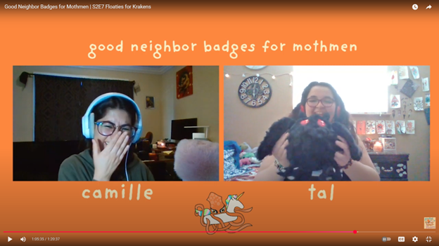 Split screen with two side by side webcast images of people interacting. One laughs while the other holds a mothman plush toy.