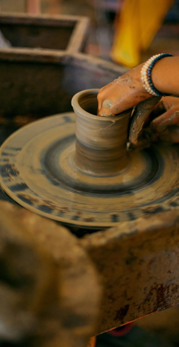 Throwing a clay vessel on a wheel.
