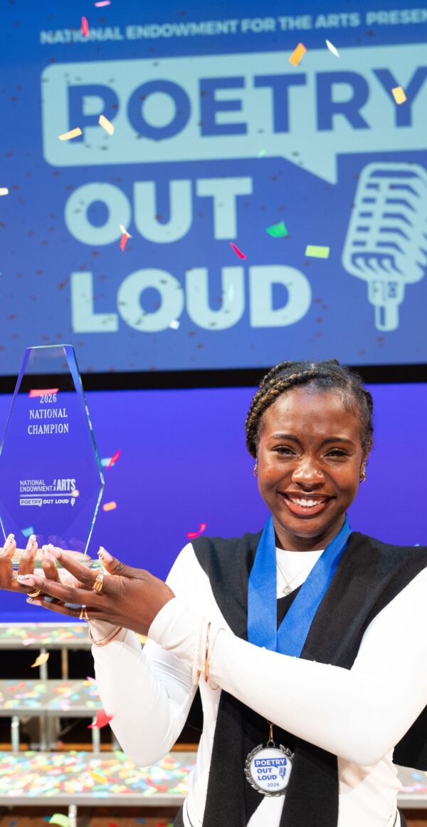 Jayda Dawn holds up the POL Champion trophy on the stage following the competition.