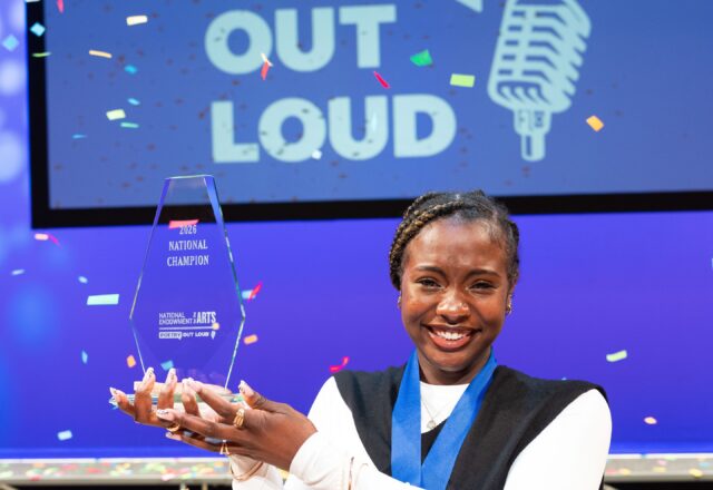 Jayda Dawn holds up the POL Champion trophy on the stage following the competition.