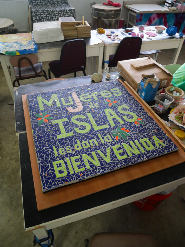 Un letrero de mosaico de Mujeres de Islas en su taller de cerámica.