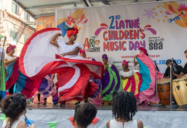 Dancers in brightly colored skirts perform on an outdoor stage.